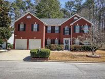 Charming brick home featuring a well-manicured lawn, two-car garage, and inviting front entrance at 1074 Deshon Trl, Lithonia, GA 30058