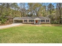 Charming single-story home featuring a brick exterior, a carport, and a spacious front yard at 3129 Thrasher Cir, Decatur, GA 30032
