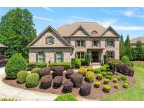 Beautiful brick home with a manicured front yard and lush landscaping at 5330 Cole Creek Ln, Cumming, GA 30040