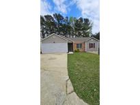 Charming single story home with mature trees, well-maintained lawn and attached garage at 5760 Old Carriage Dr, Atlanta, GA 30349
