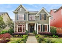 Charming two-story home with stone accents, red framed windows, lush landscaping and inviting curb appeal at 963 Manor Parc Dr, Decatur, GA 30033