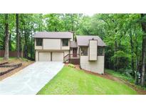 Charming home boasts a two-car garage and beautifully landscaped front yard with mature trees at 4579 Glenforest Ne Dr, Roswell, GA 30075