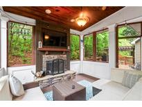 Inviting sunroom with stone fireplace, wood ceiling, and ample natural light offers cozy relaxation and serene views at 5729 Brookstone Nw Walk, Acworth, GA 30101