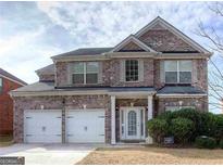 Charming two-story brick home with a well-maintained front yard and a two-car garage at 3642 Sunbridge Dr, Snellville, GA 30039