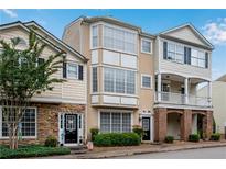Charming townhome featuring a unique bay window design and inviting curb appeal with mature landscaping at 111 Riverstone Commons Cir, Canton, GA 30114