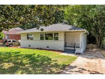 Charming, one story home with a well-maintained lawn and a driveway leading to the house at 732 Quaker Sw St, Atlanta, GA 30315