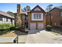 Charming two-story brick home featuring a stone chimney, attached two-car garage, and manicured landscaping at 4782 Lakeway, Alpharetta, GA 30005