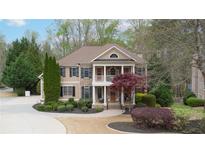 Charming two-story home with a welcoming front porch and manicured landscaping at 4981 Millwood Dr, Canton, GA 30114