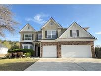 Inviting home featuring a well-manicured lawn, brick accents, and a two-car garage at 3354 Preserve Run Trl, Loganville, GA 30052