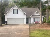 Charming home with a two-car garage, black shutters, and mature trees at 355 Freeman Dr, Covington, GA 30016