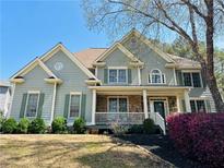 Charming two-story home with stone accents, a covered porch and manicured landscaping at 4658 Glory Maple Trce, Powder Springs, GA 30127