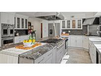 Bright kitchen featuring a center island with cooktop, stainless steel appliances, and white cabinetry at 3762 Frederica Rd, Berkeley Lake, GA 30096