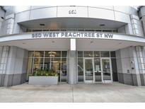 Contemporary building entrance at 950 West Peachtree Street NW with glass doors and planters at 950 W Peachtree Nw St # 904, Atlanta, GA 30309
