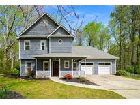 Charming two-story home with a covered front porch, attached garage, and well-manicured lawn and landscape at 3021 Favor Pines Sw Ct, Marietta, GA 30060