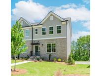 Charming townhome with brick facade, gray siding, manicured lawn and inviting front entrance at 1250 Ainsworth Aly # 42, Sugar Hill, GA 30518