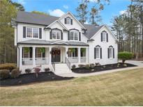 Charming two-story home with a welcoming front porch, black shutters, and professionally landscaped yard at 735 River Ridge Ln, Suwanee, GA 30024