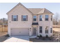 Beautiful two-story brick home featuring a 2-car garage and manicured front lawn at 2797 Malton Way, Loganville, GA 30052