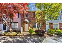 Charming brick townhouse with mature trees and well-manicured landscaping offers great curb appeal at 8827 Applegate Ln, Atlanta, GA 30350