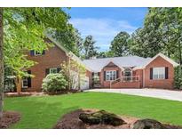 Beautiful brick home with a well-manicured lawn and mature trees in a serene setting at 7350 S Mitchell Ct, Villa Rica, GA 30180