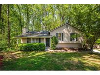 Charming single-story home with a well-manicured lawn and mature trees at 1131 Hershey Dr, Marietta, GA 30062