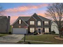 Charming two-story home featuring stone accents, a well-manicured lawn, and a two-car garage at 2277 Shady Maple Trl, Loganville, GA 30052