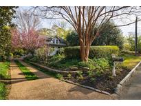 Charming home featuring a meticulously landscaped front yard with flowering trees and lush greenery at 202 Lakeview Ave, Atlanta, GA 30305