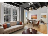 Modern living room featuring hardwood floors, large windows, and a comfortable sofa with decorative pillows at 32 Peachtree Nw St # 1303, Atlanta, GA 30303
