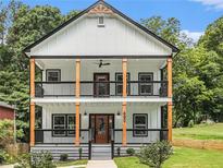 Stunning two-story home with a double porch, light facade, and beautifully landscaped yard at 490 Third Ave, Scottdale, GA 30079