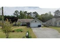 Charming single-story home with a well-maintained front yard and attached garage, perfect for suburban living at 1109 Granite Ln, Loganville, GA 30052
