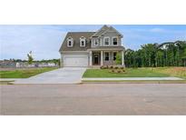 Charming two-story home with a well-manicured lawn, attached garage, and inviting front porch at 255 Arnewood Cir, Mcdonough, GA 30253
