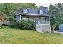 Charming home featuring dormer windows, a front porch, and lush landscaping at 470 Ashland Manor Dr, Lawrenceville, GA 30045
