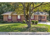 Charming single-story brick home featuring a well-maintained lawn and mature tree at 37 Crystal River Dr, Riverdale, GA 30274