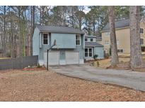 Charming light blue home features a two-car garage and basketball hoop in a wooded suburban neighborhood at 670 Westbrook Pl, Lawrenceville, GA 30044
