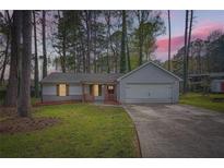 Charming single-Gathering home boasts a well-manicured front yard, driveway, and attached garage at 9053 Franklin Ct, Jonesboro, GA 30238