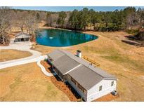 Stunning aerial view of a charming home with a private pond and meticulously landscaped grounds at 96 Sam Alexander Rd, Douglasville, GA 30134