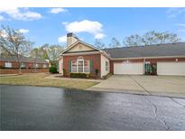 Charming brick home featuring a two-car garage, well-kept lawn and manicured landscape at 460 Tribble Gap Rd # 1004, Cumming, GA 30040