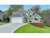 Charming two-story home featuring a two-car garage and a cozy front porch for outdoor relaxation at 4995 Hyde Ct, Cumming, GA 30040