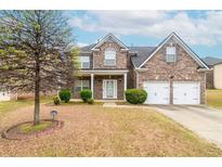 Charming brick home featuring a two-car garage, well-manicured lawn, and inviting front porch at 3019 Iona Ct, Snellville, GA 30039