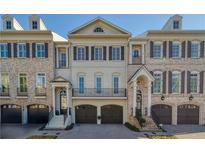 Charming brick townhome with symmetrical design, multiple windows, and integrated garages at 9044 Riverbend Manor, Alpharetta, GA 30022