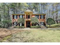 Charming brick home featuring dual staircases and a welcoming, covered entryway with a columned portico at 30 Plantation Ne Dr # B, Atlanta, GA 30324