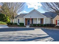 Charming single-story home with blue door, neat landscaping, and ample parking on a sunny day at 2368 Barrett Cottage # 17, Marietta, GA 30066