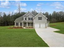 Charming gray two-story home with a well-manicured lawn and a two-car garage at 3292 Lions Ruby Ln, Atlanta, GA 30349