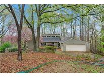 Inviting home featuring beautiful landscaping and a spacious two-car garage at 3696 Suwanee Creek Ct, Suwanee, GA 30024