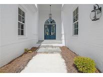 Elegant entryway showcasing a blue front door, white brick exterior, and a decorative hanging light fixture at 103 Candler Loop, Acworth, GA 30101
