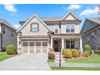 Charming two-story home with a brick and siding exterior, a well-manicured lawn, and an attached two-car garage at 11395 Crestview Ter, Johns Creek, GA 30024
