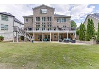 Expansive backyard featuring a multi-level deck, manicured lawn, and outdoor seating, perfect for relaxation at 1718 Autumn Sage Dr, Dacula, GA 30019