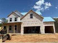 New construction home featuring a two-car garage and large windows awaiting its final touches at 363 Riverwood Pass, Dallas, GA 30157