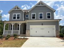 Charming two-story home with a gray exterior, white trim, a front porch, and a two-car garage at 373 Riverwood Pass, Dallas, GA 30157