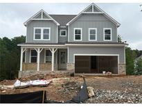 New home features gray siding, brick foundation, covered porch, and an attached two-car garage at 373 Riverwood Pass, Dallas, GA 30157