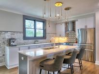 Modern kitchen featuring a center island with bar seating, stainless steel appliances, and stylish pendant lighting at 88 Peachtree Memorial Nw Dr # 88, Atlanta, GA 30309